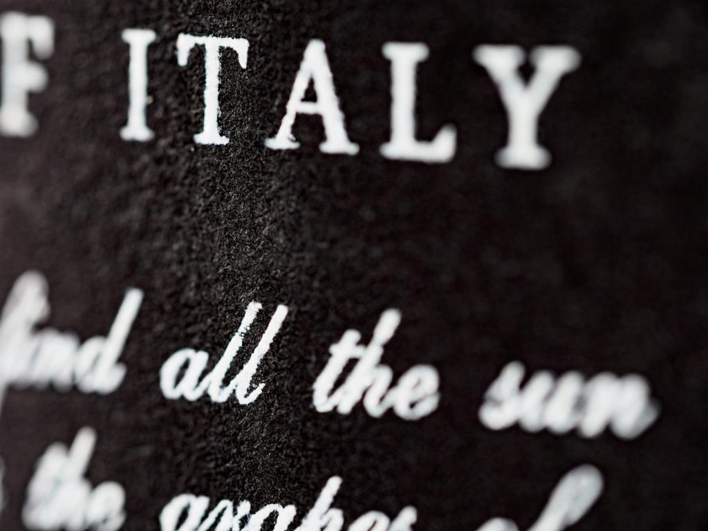 Detailed close-up of textured black surface with white typography 'ITALY.'