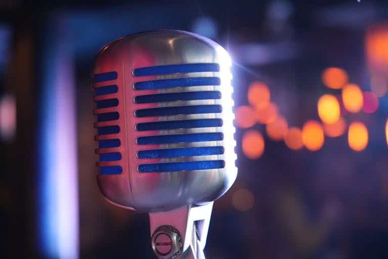 Close-up of a classic microphone with colorful bokeh, ideal for music and performance themes.