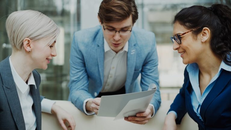 Three professionals discussing a document together