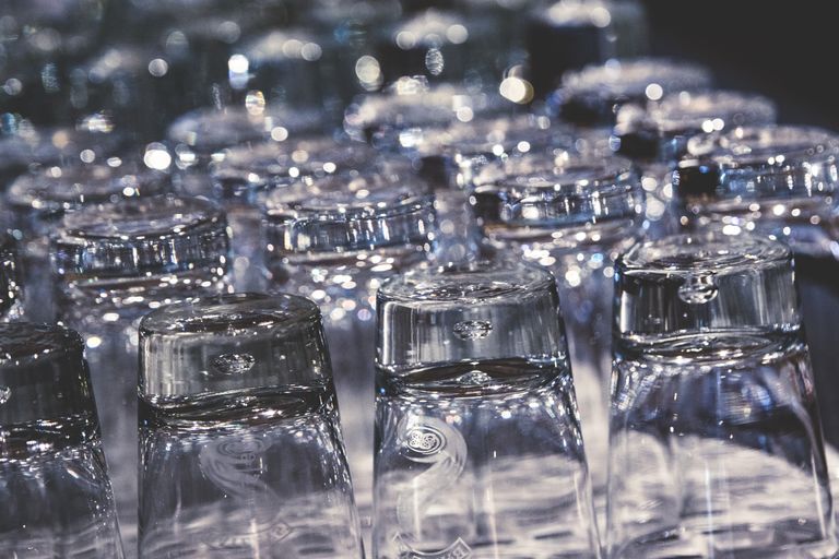 Close-up of crystal clear upside-down drinking glasses with an elegant reflection.