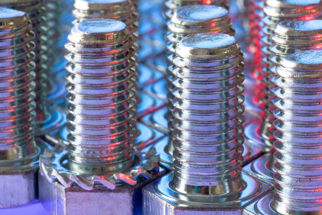 Detailed view of shiny metal screws with colorful reflections and selective focus.