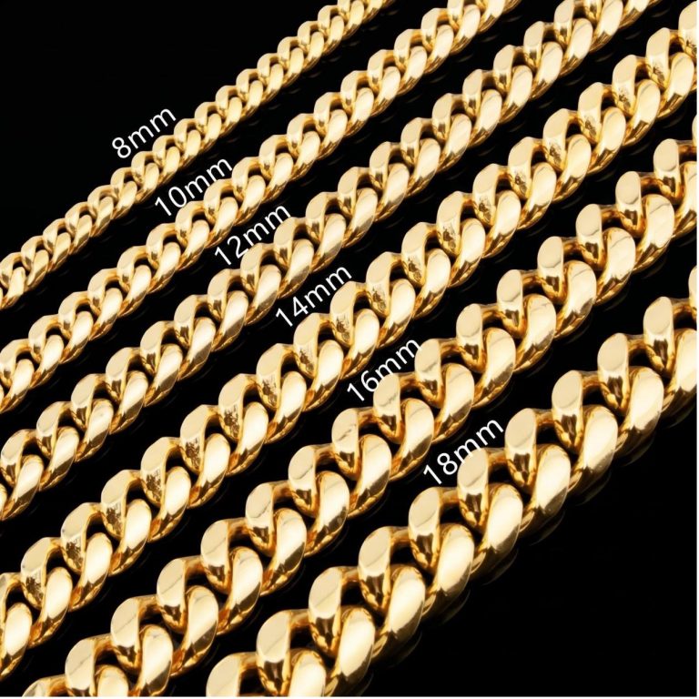A close-up detail of a silver Cuban link chain worn over a dark outfit.