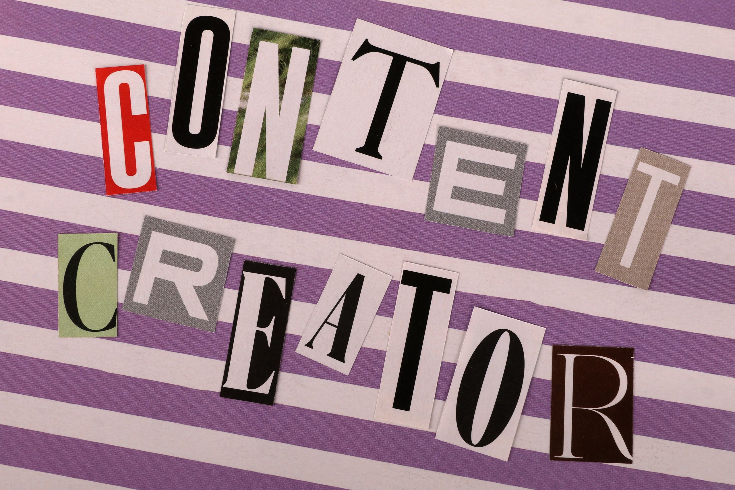 Artistic arrangement of 'Content Creator' text in a collage style on striped background.